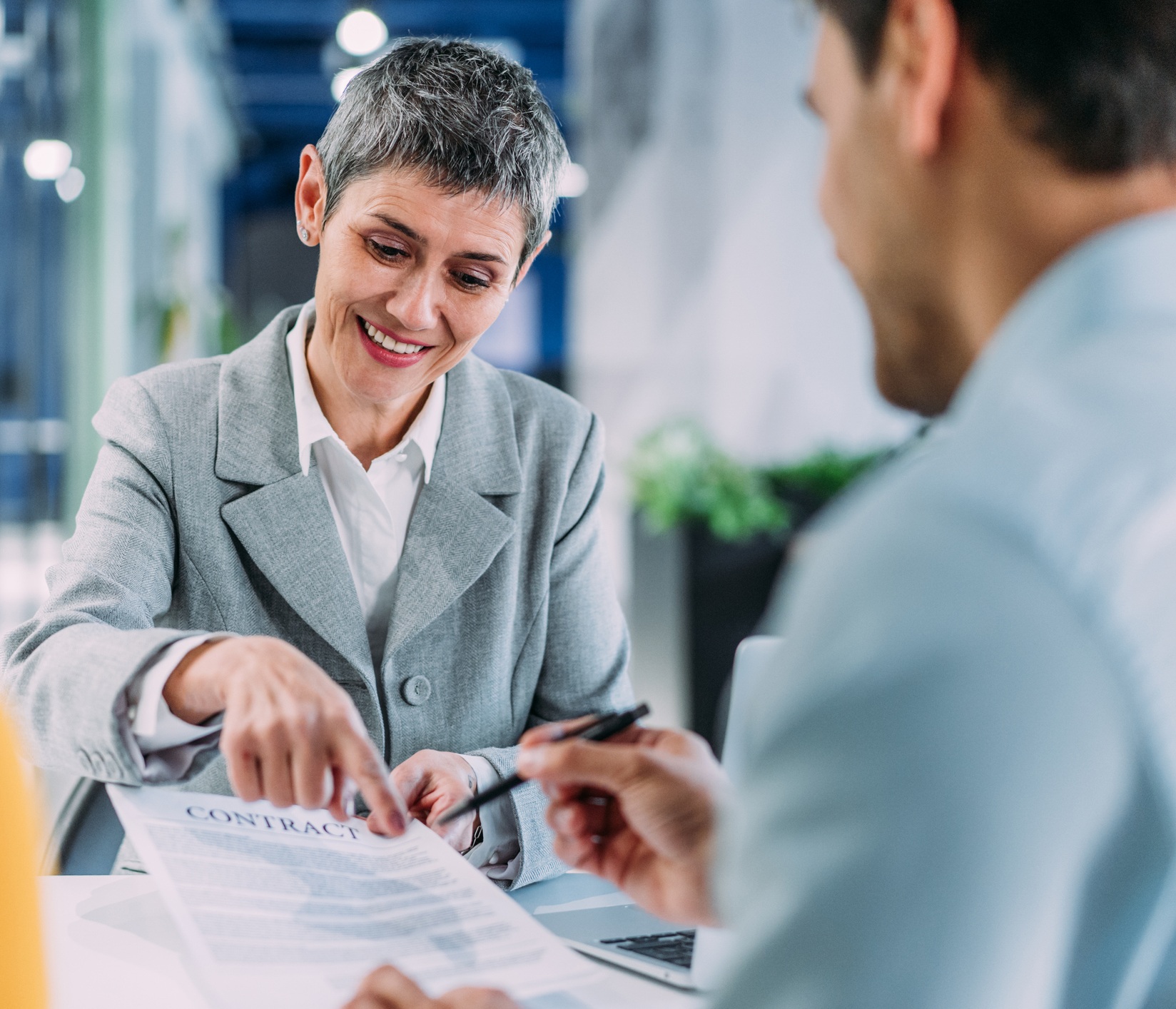 Business persons signing a document during a meeting in board room.
